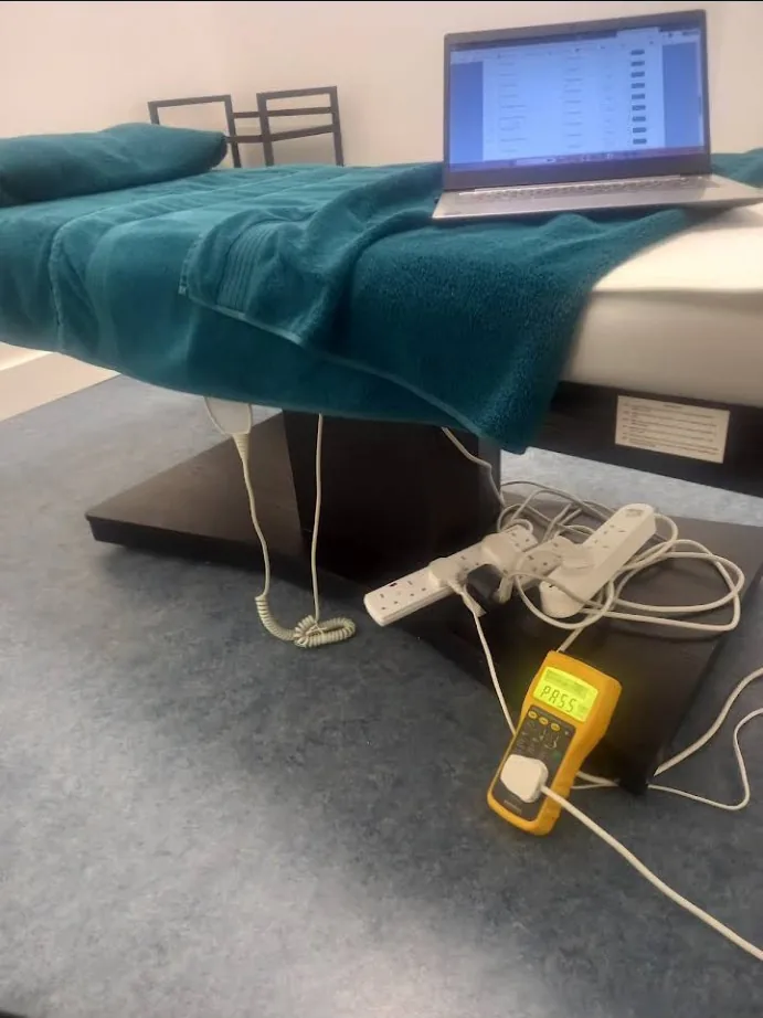 Treatment bed, laptop and extension leads undergoing PAT testing